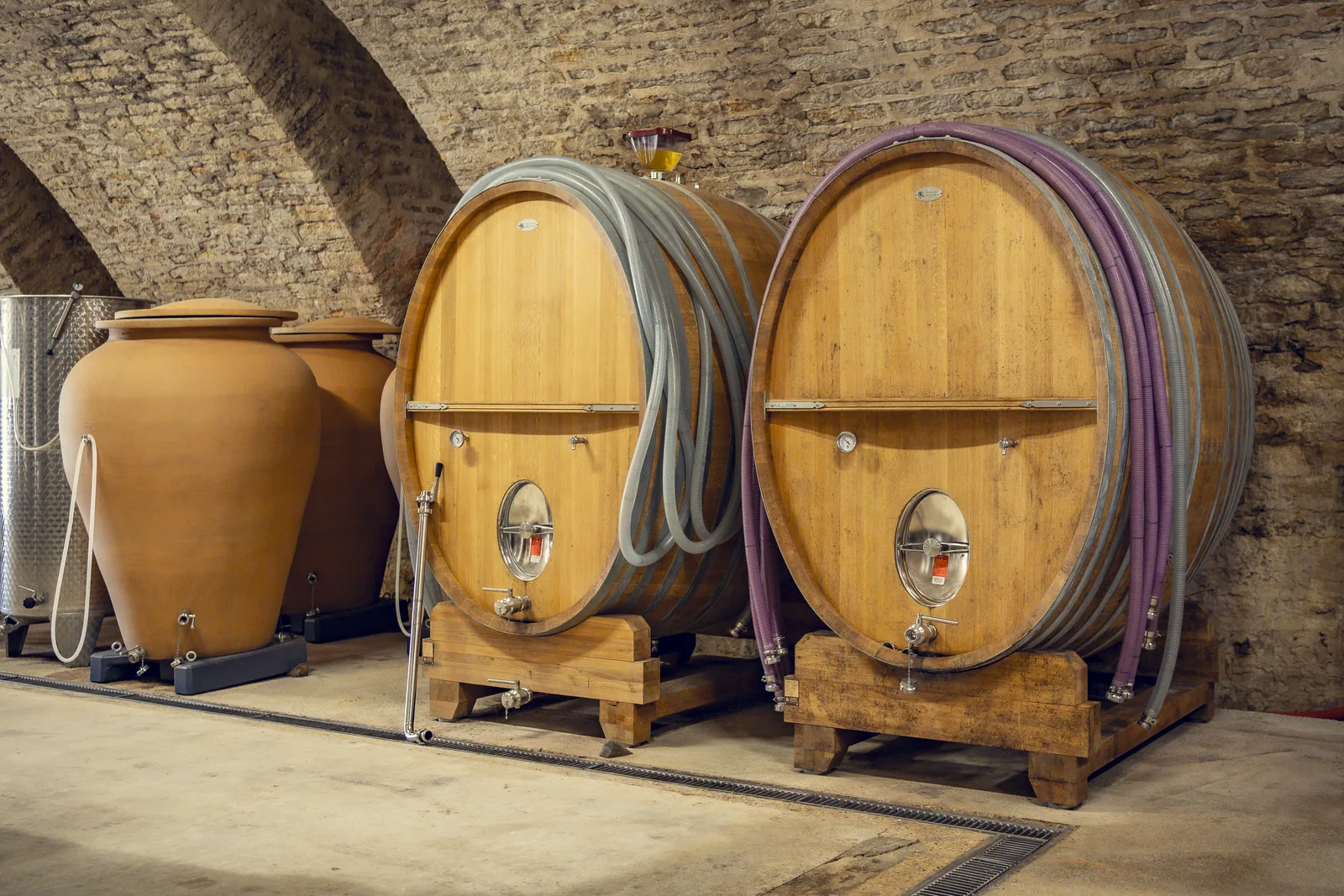 Foudres de chêne alignés dans le chai voûté
